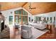 Bright living room featuring wood-paneled ceiling, fireplace, large windows, and access to the outdoor scenery at 6259 River Cabin Ln, Charlotte, NC 28278
