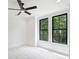 Bright bedroom features plush carpet, a modern ceiling fan, and large windows with wooded view at 7011 Chateau Bordeaux Ln, Charlotte, NC 28270