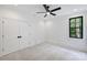 Bright bedroom offers neutral carpet, a modern ceiling fan, and a view to the outdoors at 7011 Chateau Bordeaux Ln, Charlotte, NC 28270