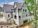 Rear exterior of a multi-story home featuring painted brick, siding, a walkout basement, and mature trees at 7011 Chateau Bordeaux Ln, Charlotte, NC 28270