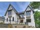 Beautiful two-story home with white brick, gray siding, black trim, and manicured landscaping at 7011 Chateau Bordeaux Ln, Charlotte, NC 28270