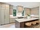 Bright kitchen featuring a center island with bar stools, custom cabinets, and modern appliances at 7011 Chateau Bordeaux Ln, Charlotte, NC 28270