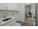 Well-lit laundry room with quartz countertops, modern sink and faucet, and herringbone floors at 7011 Chateau Bordeaux Ln, Charlotte, NC 28270