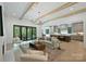 Bright living room featuring hardwood floors, beamed ceilings, and a seamless transition to the modern kitchen at 7011 Chateau Bordeaux Ln, Charlotte, NC 28270