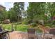 Outdoor deck and grill overlooking manicured backyard with shed and mature trees at 7164 Moss Point Dr, Charlotte, NC 28277