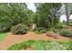 Relaxing backyard space with lush landscaping, a seating area, and a charming shed, perfect for outdoor enjoyment at 7164 Moss Point Dr, Charlotte, NC 28277