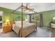 Spacious bedroom with a luxurious four-poster bed, carpeted floor, and bright window at 7164 Moss Point Dr, Charlotte, NC 28277