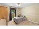 Cozy bedroom featuring a single bed, a window with decorative curtains, and a neutral palette at 7164 Moss Point Dr, Charlotte, NC 28277