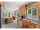 A kitchen that features wooden cabinets, double sinks, stainless steel appliances, and a view of the backyard at 7164 Moss Point Dr, Charlotte, NC 28277