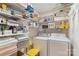Organized laundry room with shelving, storage, washer, and dryer at 7164 Moss Point Dr, Charlotte, NC 28277