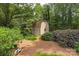 View of the backyard shed surrounded by lush landscaping, providing storage and an attractive focal point in the yard at 7164 Moss Point Dr, Charlotte, NC 28277