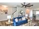 Bright living room showcasing a blue sofa, wood floors, and modern ceiling fan at 8388 Waxhaw Hwy, Waxhaw, NC 28173