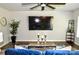 Stylish living room featuring a large screen TV, modern decor, and wood flooring at 8388 Waxhaw Hwy, Waxhaw, NC 28173