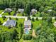 Scenic aerial view of a neighborhood, showcasing lush lawns, mature trees, and a fenced-in pool at 9801 Blackbird Hill Ln, Mint Hill, NC 28227