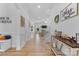 Bright foyer featuring wood floors, white walls, a staircase, and decorative wall art at 9801 Blackbird Hill Ln, Mint Hill, NC 28227