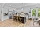 Bright, open kitchen with stainless steel appliances, center island and wood floors at 9801 Blackbird Hill Ln, Mint Hill, NC 28227