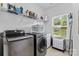 Modern laundry room featuring stainless steel washer and dryer, with built-in storage at 9801 Blackbird Hill Ln, Mint Hill, NC 28227
