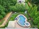 Aerial view of a backyard with a fenced in pool, hot tub, lounge chairs, and green landscaping at 9801 Blackbird Hill Ln, Mint Hill, NC 28227