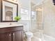 Bathroom with dark wood vanity, shower with tiled surround, and a window at 1009 Hampton Grove Rd, Waxhaw, NC 28173
