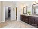 Well-lit bathroom featuring a double sink vanity with dark wood cabinets, granite countertops, and a large walk-in closet at 1009 Hampton Grove Rd, Waxhaw, NC 28173