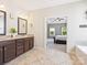 Bathroom featuring a double sink vanity, granite countertops and tile flooring, leading to the carpeted main bedroom at 1009 Hampton Grove Rd, Waxhaw, NC 28173