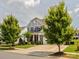 Beautiful two-story home with a well-manicured lawn, mature trees, and a welcoming front porch at 1009 Hampton Grove Rd, Waxhaw, NC 28173