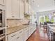 Bright kitchen with white cabinets, granite countertops, tile backsplash, and hardwood floors, adjacent to a breakfast nook at 1009 Hampton Grove Rd, Waxhaw, NC 28173