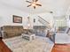 Living room with staircase, ceiling fan, gray sofas, and a stone fireplace at 1009 Hampton Grove Rd, Waxhaw, NC 28173