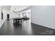 Wide-open basement area featuring dark-stained floors, a pool table, gym equipment, and a black sofa at 1009 Murandy Ln, Matthews, NC 28104