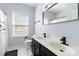 Bathroom with a double vanity, framed mirror, and white tile flooring at 1009 Murandy Ln, Matthews, NC 28104