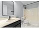 Standard bathroom featuring a single sink vanity with black cabinet, toilet, and shower-tub combination at 1009 Murandy Ln, Matthews, NC 28104