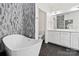 Bright bathroom with a modern freestanding tub, dual sink vanity with white cabinets and gray accent wall at 1009 Murandy Ln, Matthews, NC 28104