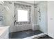 Elegant bathroom with glass shower featuring dual showerheads, black penny tile floor and a marble-tiled wall at 1009 Murandy Ln, Matthews, NC 28104