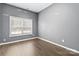 Neutral bedroom with gray walls featuring hardwood flooring, double hung windows and base molding at 1009 Murandy Ln, Matthews, NC 28104