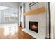 Cozy living room area with a modern fireplace, hardwood floors, and sunroom access at 1009 Murandy Ln, Matthews, NC 28104