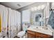 Functional bathroom featuring a floral curtain and wooden vanity at 1045 Fairway Ridge Nw Rd, Concord, NC 28027