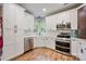 Modern kitchen with stainless steel appliances, white cabinetry, and hardwood floors at 1045 Fairway Ridge Nw Rd, Concord, NC 28027