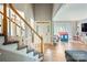 View of the open-concept living room showcasing hardwood floors, stairs, and bay window with sheer curtains at 1045 Fairway Ridge Nw Rd, Concord, NC 28027