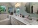 Bright bathroom with dual sinks, decorative mirrors, and garden tub with a large window view at 110 Club Dr, Mooresville, NC 28115