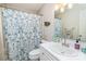 Well-lit bathroom with patterned shower curtain, classic white fixtures, and ample counter space at 110 Club Dr, Mooresville, NC 28115