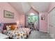 Inviting bedroom with colorful floral bedding, arched window, and soft, neutral walls at 110 Club Dr, Mooresville, NC 28115