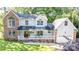 Charming two-story home with brick accents, a front porch with white railings and manicured lawn and mature landscaping at 110 Club Dr, Mooresville, NC 28115