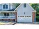 Attached two-car garage with brick accents on a light blue home with a charming front porch at 110 Club Dr, Mooresville, NC 28115