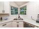 Corner kitchen view showcasing stainless steel sink, white subway tile backsplash, granite countertops, and leafy outdoor views at 110 Club Dr, Mooresville, NC 28115