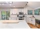 Modern kitchen with white cabinets, stainless steel appliances, subway tile backsplash, and large island with white countertop at 110 Club Dr, Mooresville, NC 28115