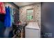 Laundry room features side-by-side washer and dryer and stylish, geometric accent wall behind hanging clothes at 110 Club Dr, Mooresville, NC 28115
