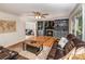 Spacious living room with built-in shelving, a fireplace, wood laminate flooring, and comfortable leather seating at 110 Club Dr, Mooresville, NC 28115
