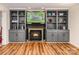 Living room with built-in shelving, a fireplace, wood laminate flooring, with a tv hung above the fireplace at 110 Club Dr, Mooresville, NC 28115