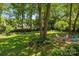 Expansive backyard with mature trees and a fire pit area, ideal for relaxation and recreation at 11329 Torino Rd, Matthews, NC 28105