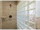 Tiled shower featuring glass blocks, bronze shower fixture, and neutral color palette at 11329 Torino Rd, Matthews, NC 28105